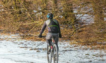 Een mountainbiker op een besneeuwd pad